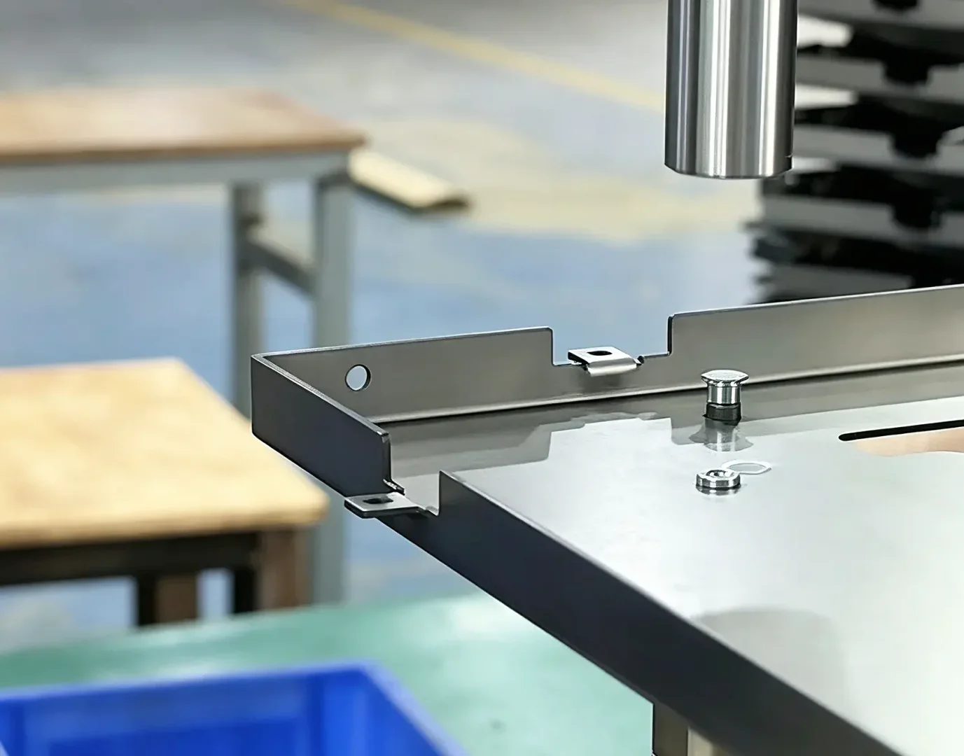 Close-up view of CNC punching process for custom electrical enclosure sheet metal parts inside manufacturing workshop