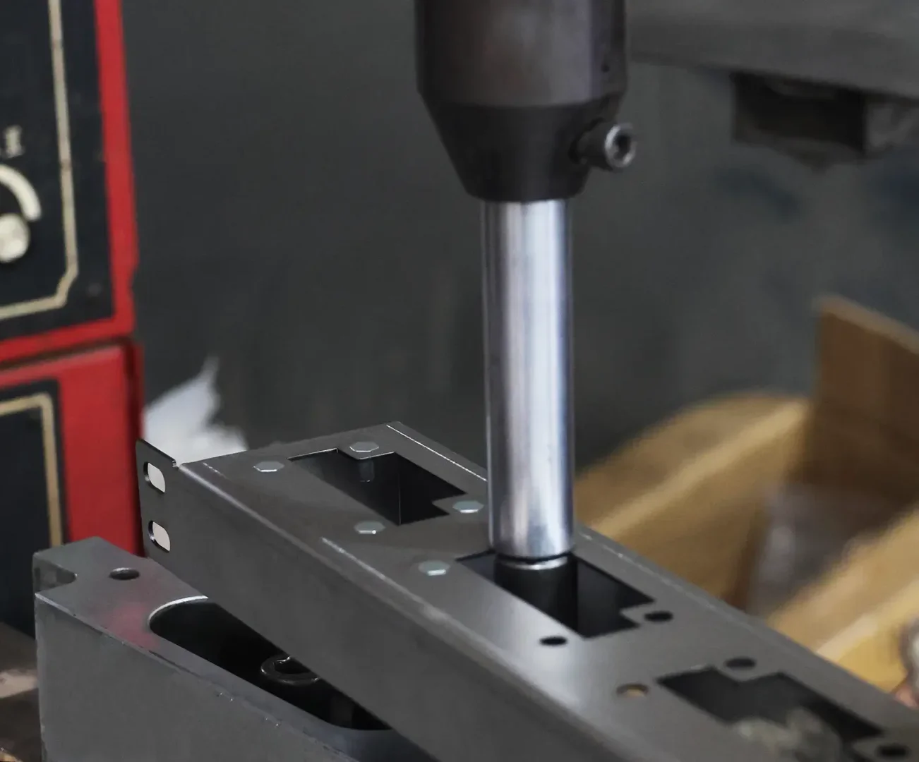 Pneumatic riveting machine assembling precision sheet metal cabinet parts in workshop