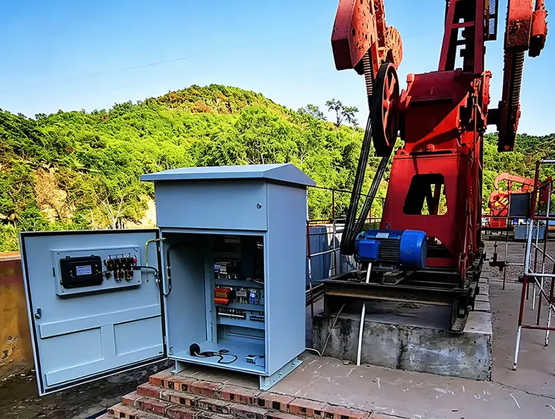 Weatherproof outdoor electrical control cabinet installed beside pump jack at onshore oil production site